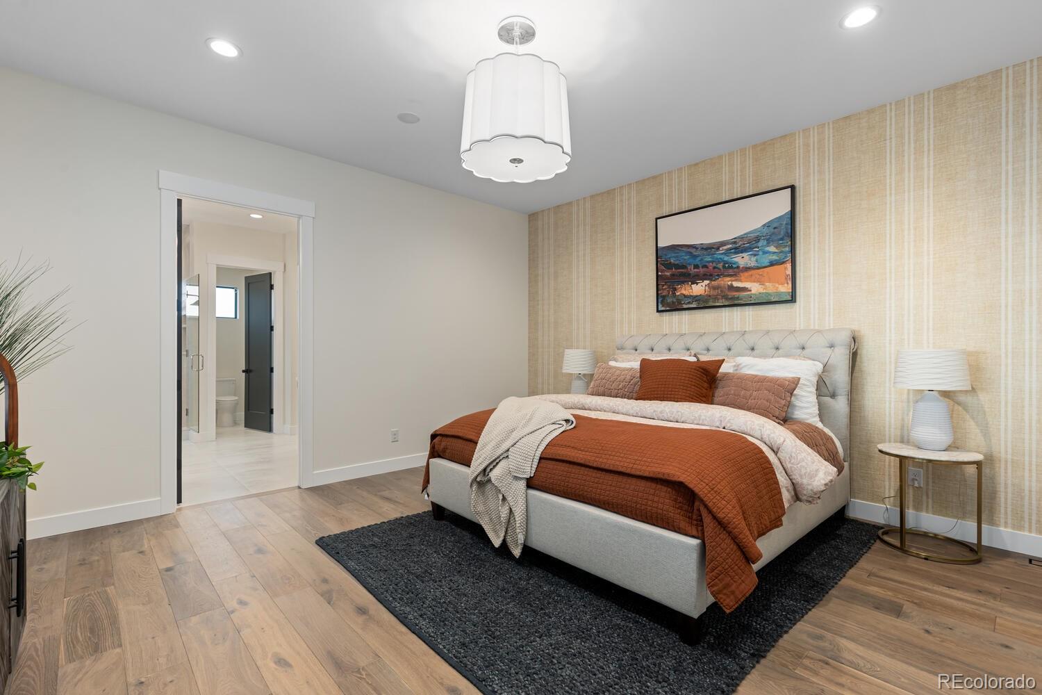 11115 Evening Hunt Road Franktown, CO 80116 - Photo 25 of 46 a spacious bedroom with a bed and a chandelier