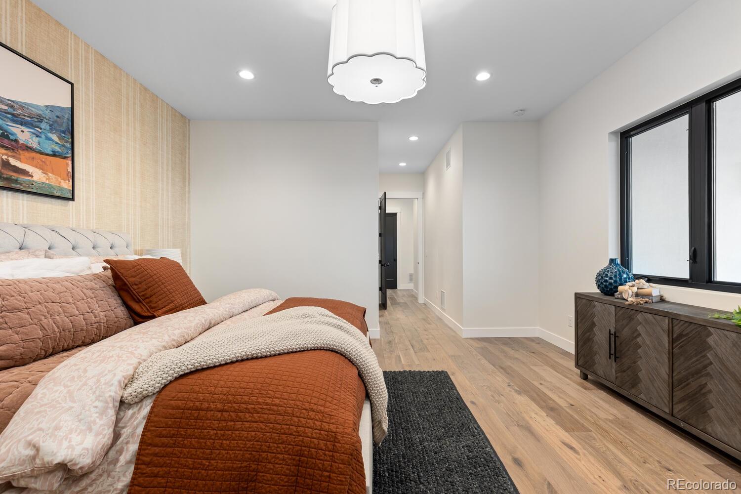 11115 Evening Hunt Road Franktown, CO 80116 - Photo 26 of 46 a bed room with a bed and a chandelier