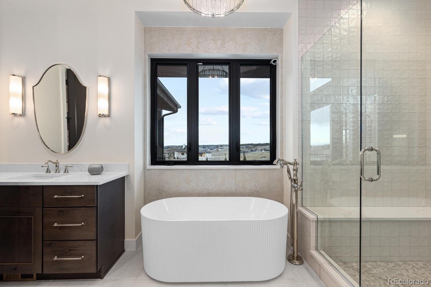 11115 Evening Hunt Road Franktown, CO 80116 - Photo 28 of 46 a bathroom with a tub a double vanity sink a mirror and a shower