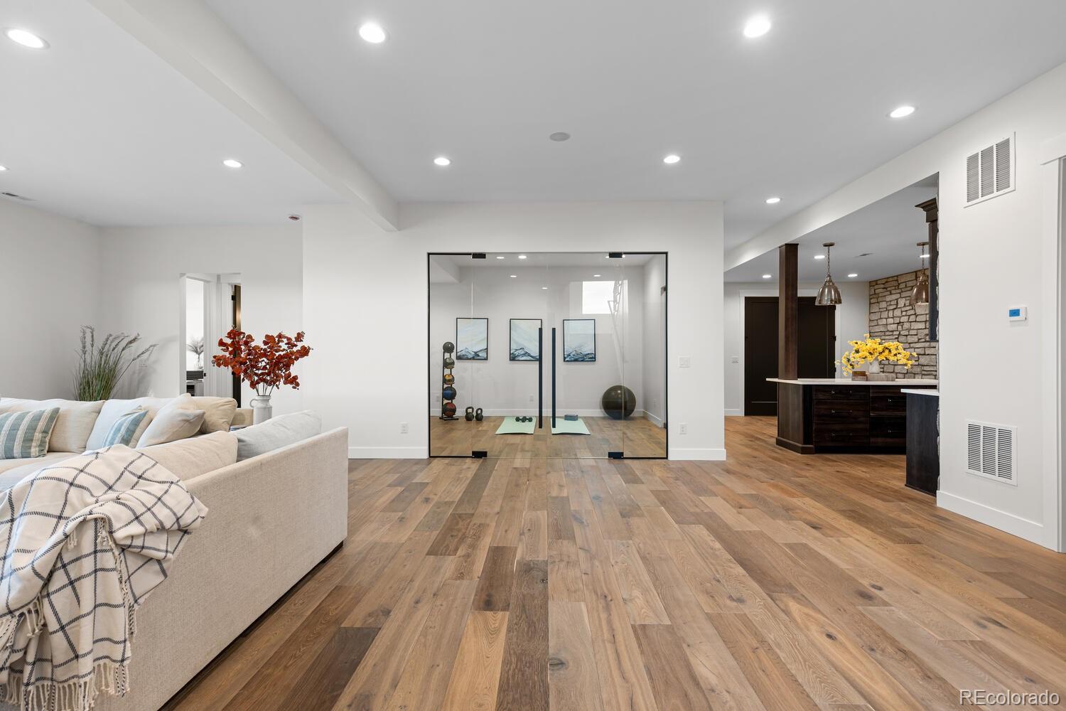 11115 Evening Hunt Road Franktown, CO 80116 - Photo 37 of 46 a large living room with stainless steel appliances kitchen island a large counter top and wooden floors