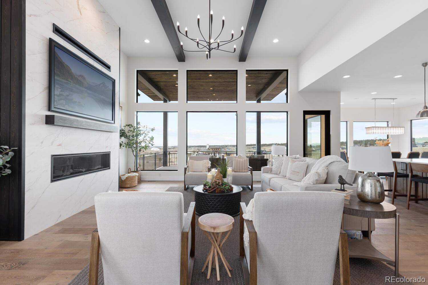 11115 Evening Hunt Road Franktown, CO 80116 - Photo 10 of 46 a living room with furniture a fireplace and a large mirror