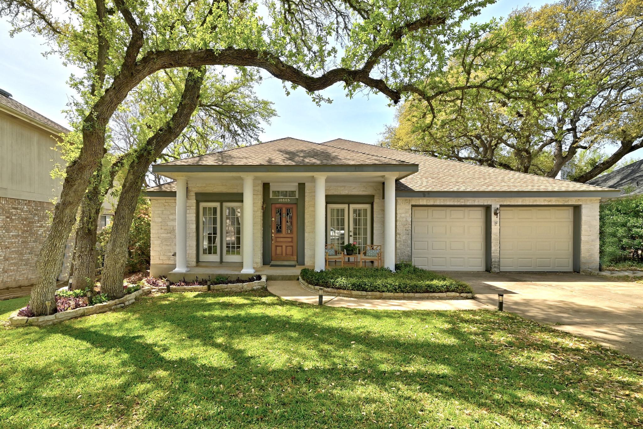 View of front facade featuring a porch, a garage, french doors, concrete driveway, and a front yard