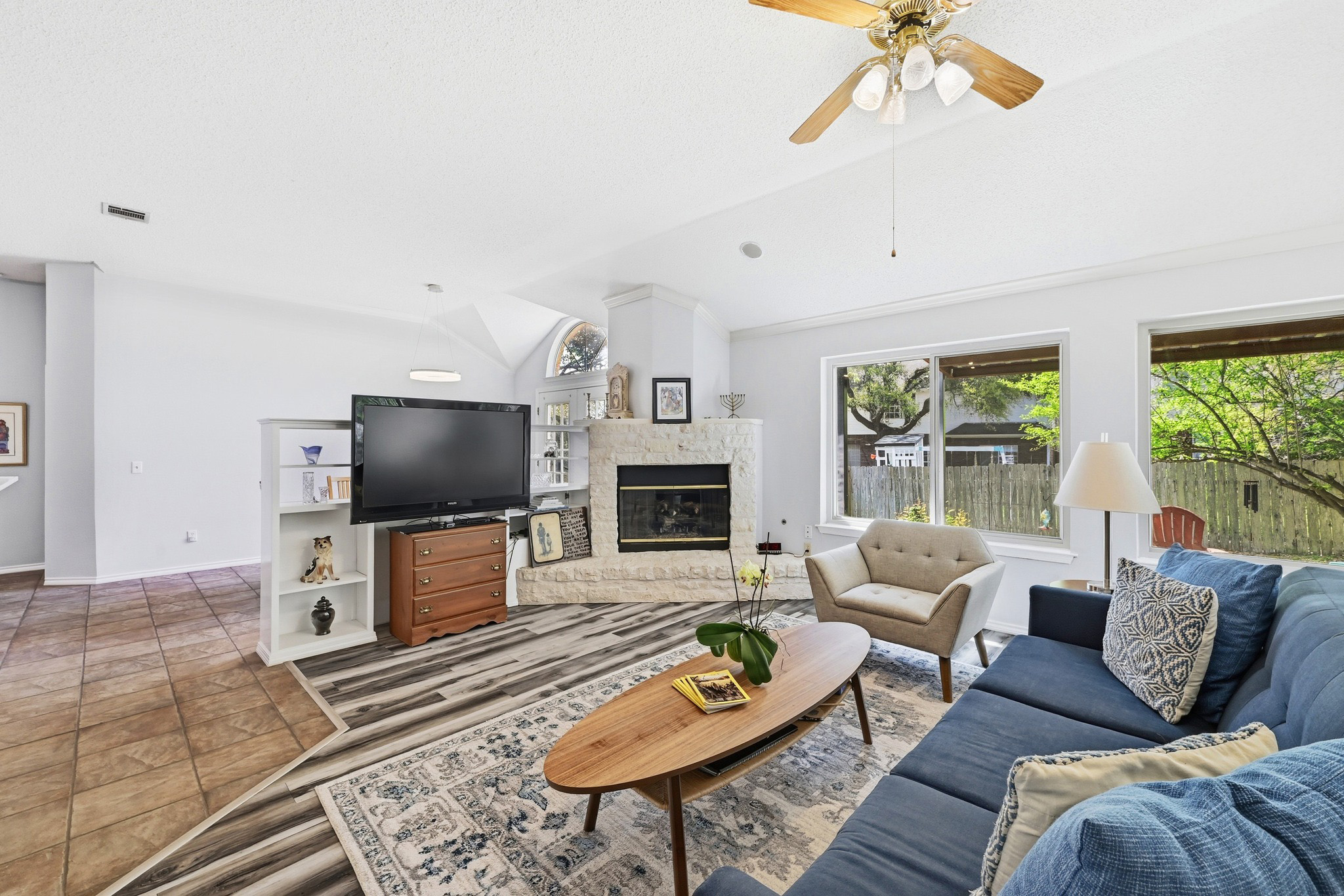 10803 Pinkney Lane Austin, TX 78739 - Photo 13 of 38 Living room featuring ceiling fan, lofted ceiling, wood finished floors, and a fireplace