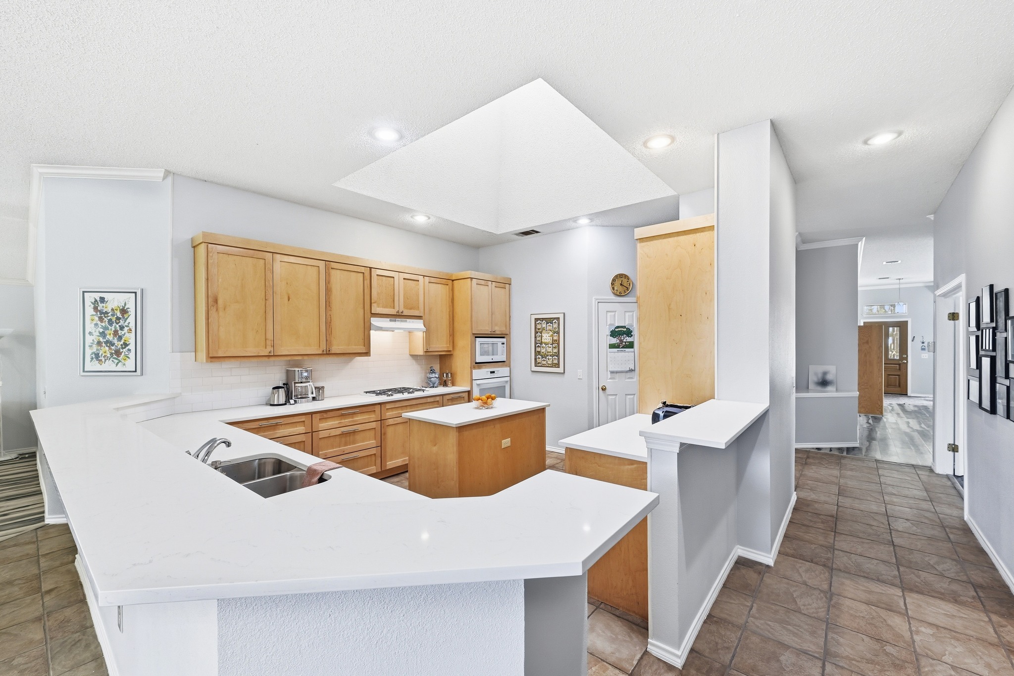 10803 Pinkney Lane Austin, TX 78739 - Photo 14 of 38 Kitchen featuring a peninsula, a center island, tasteful backsplash, light wood finish cabinetry, and recessed lighting