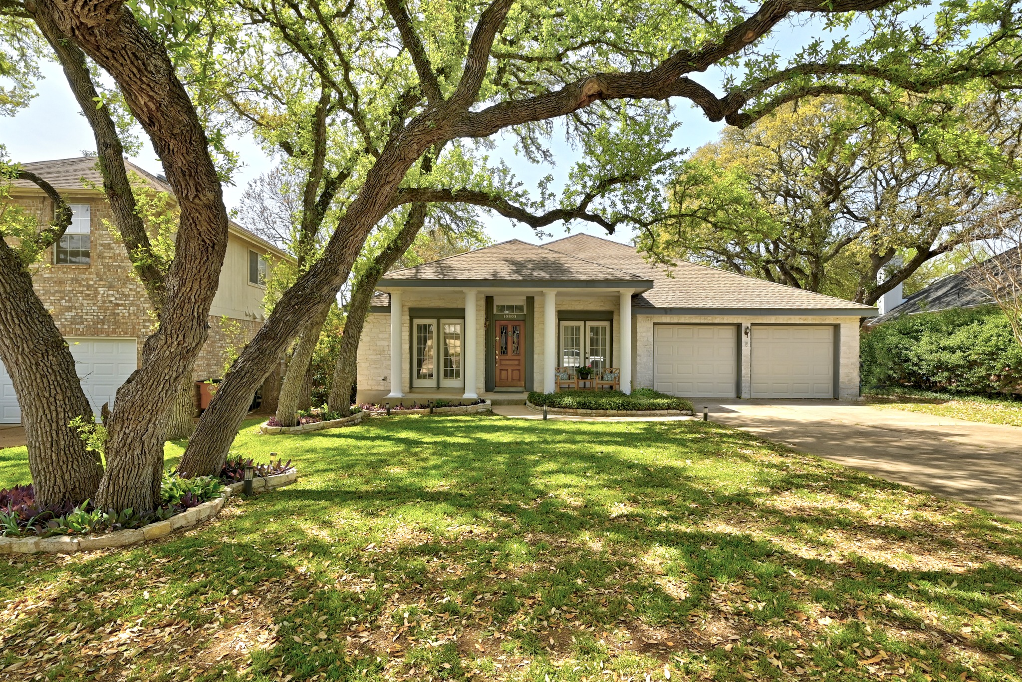 10803 Pinkney Lane Austin, TX 78739 - Photo 2 of 38 View of front of home featuring a garage, covered porch, concrete driveway, brick siding, and a front yard