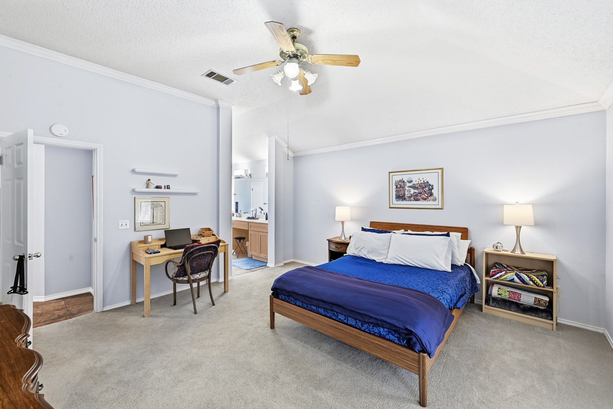 10803 Pinkney Lane Austin, TX 78739 - Photo 23 of 38 Carpeted bedroom with ornamental molding, a ceiling fan, a textured ceiling, ensuite bathroom, and a desk