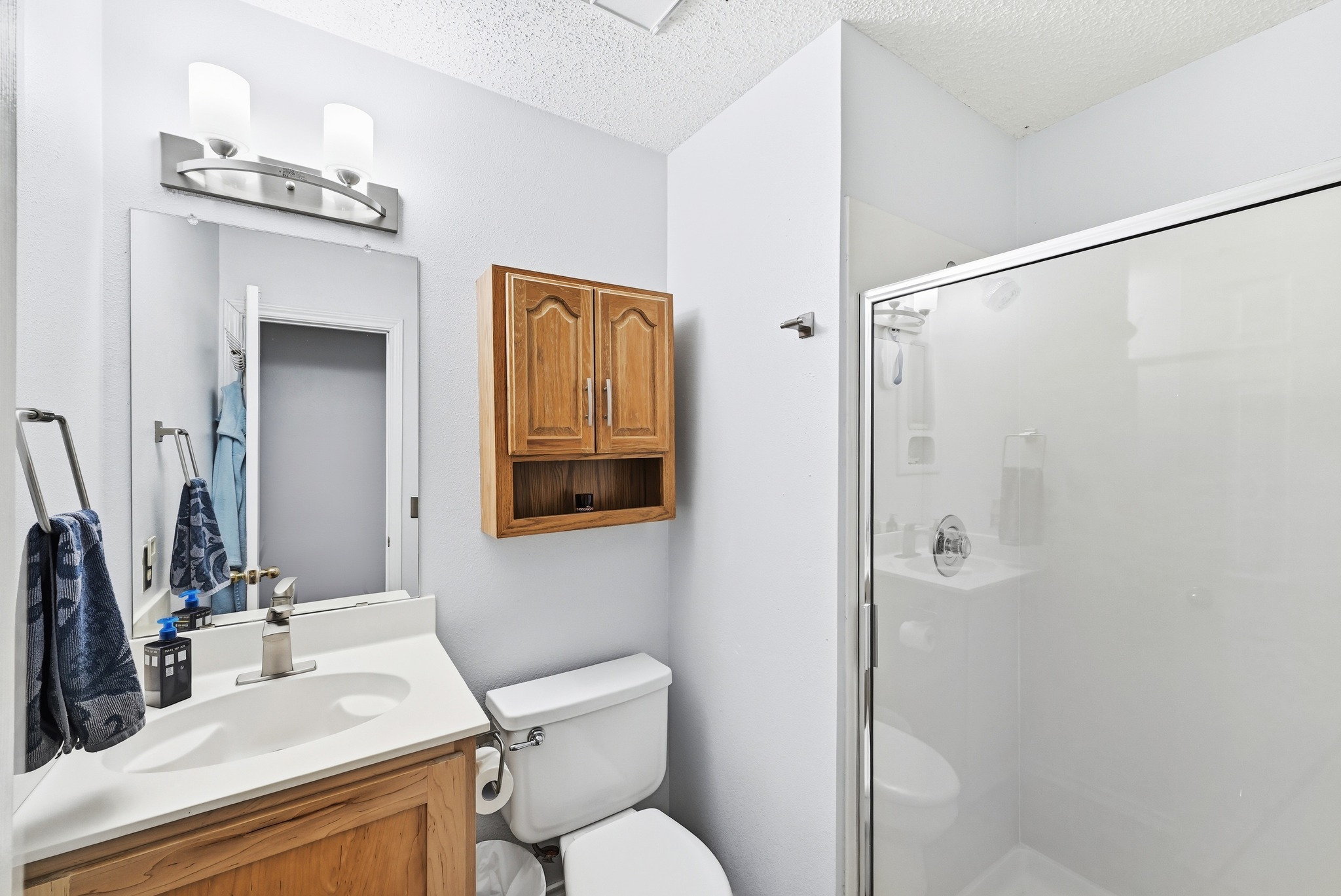 10803 Pinkney Lane Austin, TX 78739 - Photo 29 of 38 Full bath featuring vanity, a shower stall, and a textured ceiling