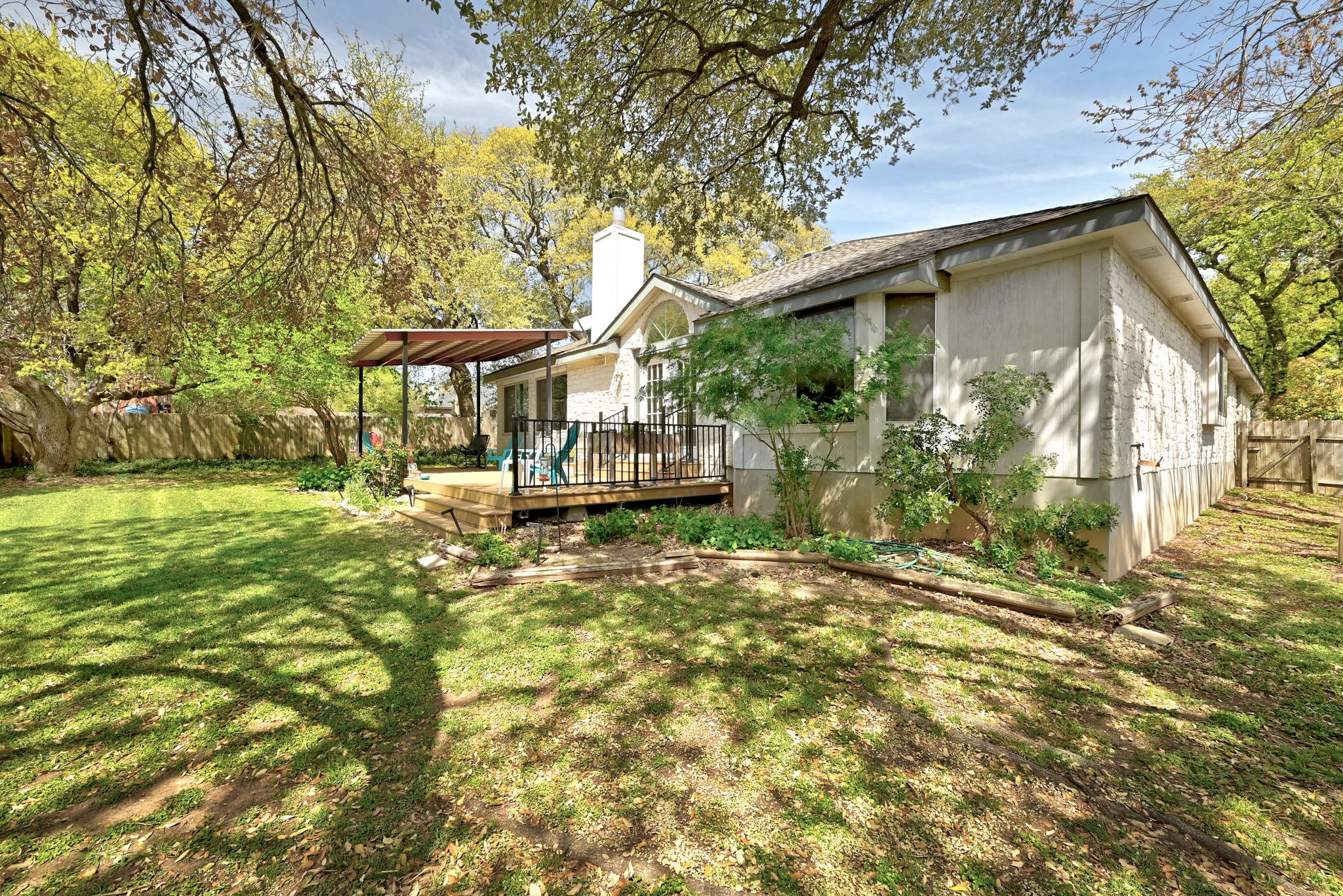 10803 Pinkney Lane Austin, TX 78739 - Photo 36 of 38 Rear view of house with a fenced backyard, a wooden deck, and a chimney