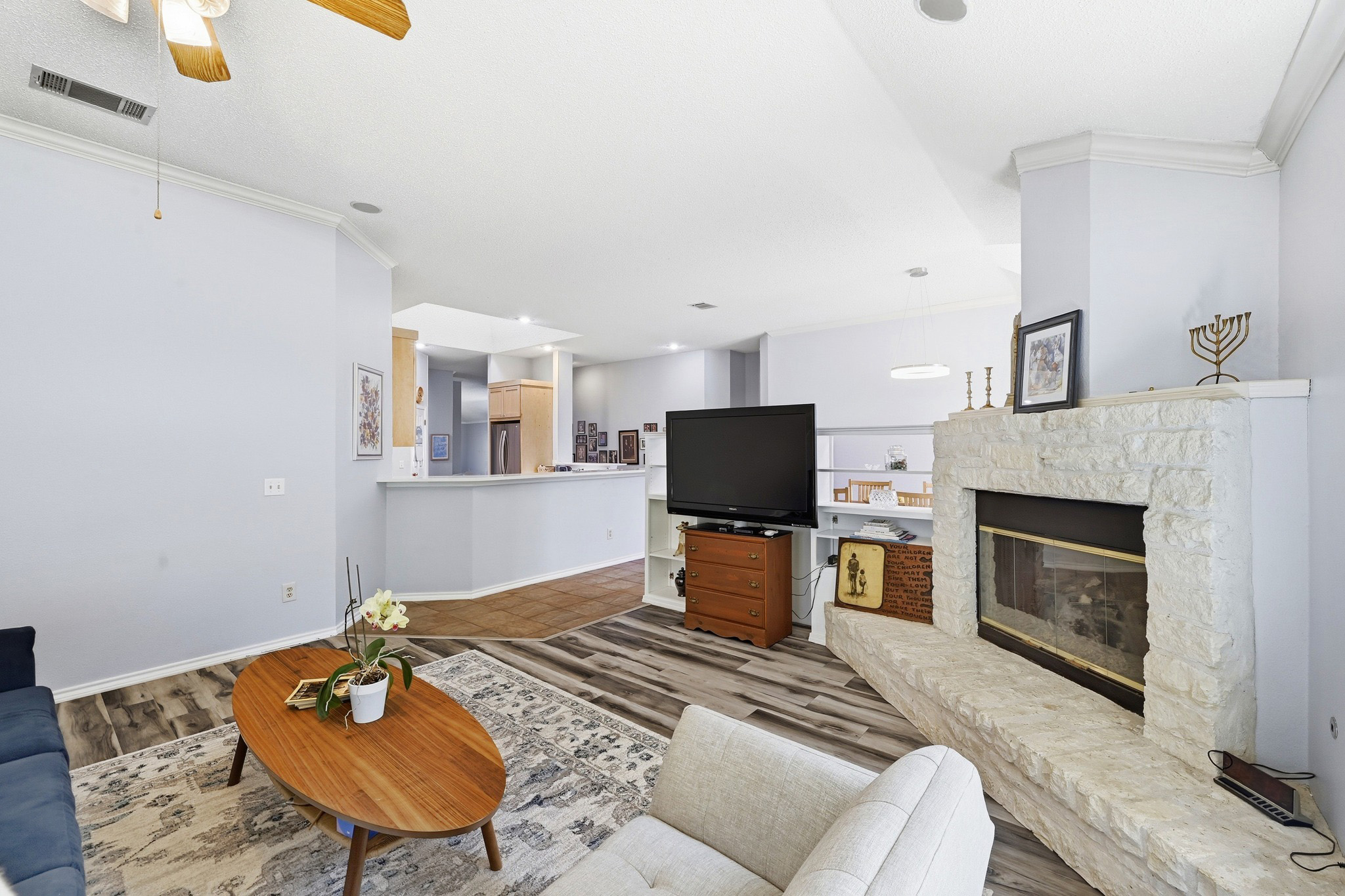 10803 Pinkney Lane Austin, TX 78739 - Photo 10 of 38 Living area featuring ornamental molding, a fireplace, a ceiling fan, and dark wood-type flooring
