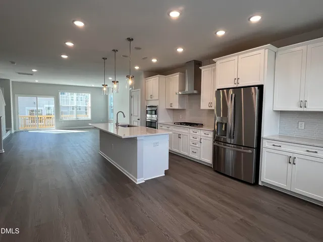 a kitchen with stainless steel appliances a refrigerator sink and cabinets