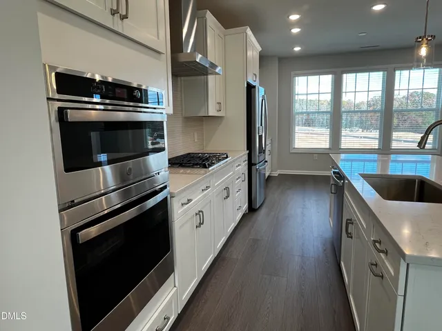 a kitchen with stainless steel appliances kitchen island granite countertop a stove and a sink