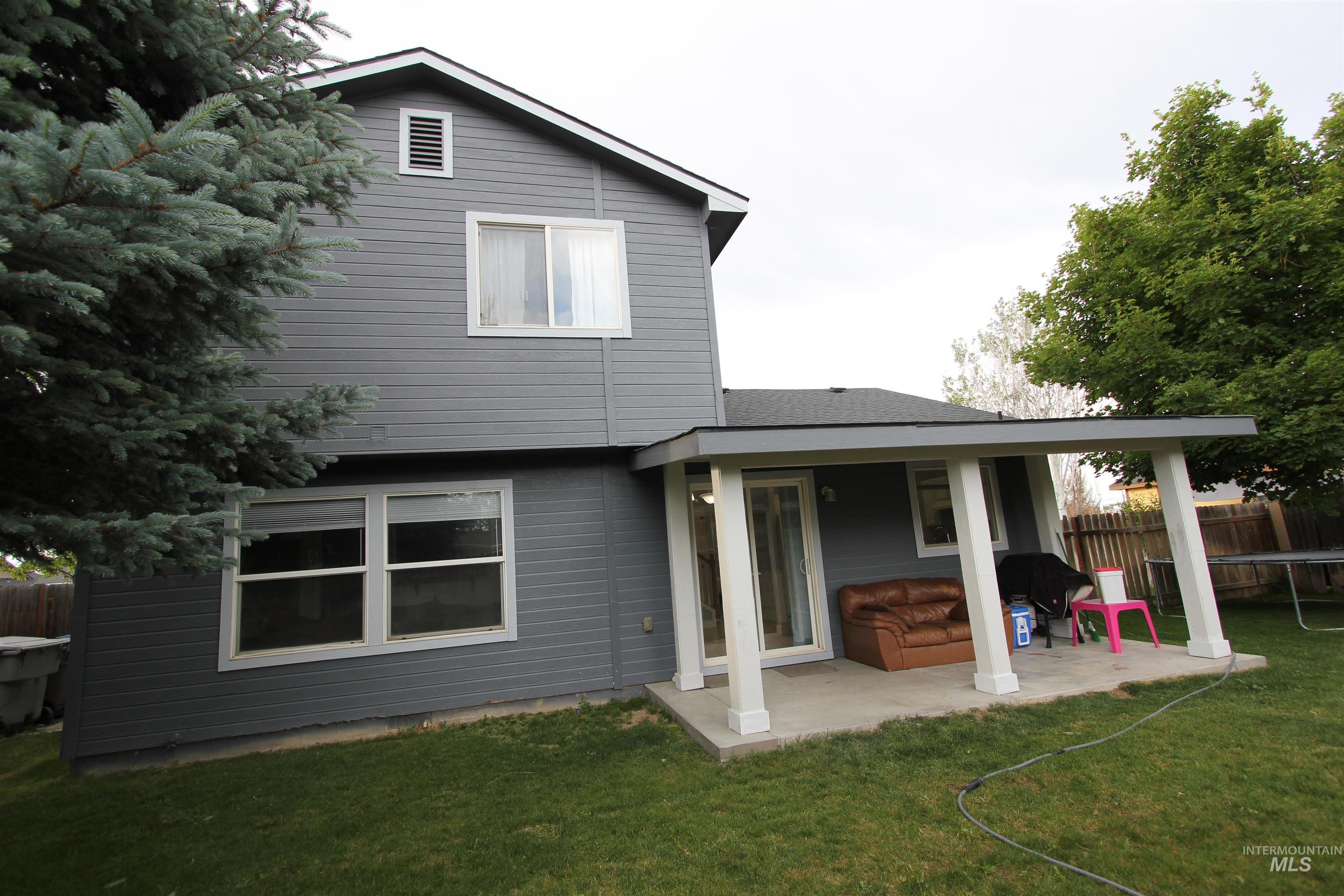 4816 Kadie Street Caldwell, ID 83607 - Photo 21 of 23 Rear exterior featuring gray siding, white trim, and a covered patio