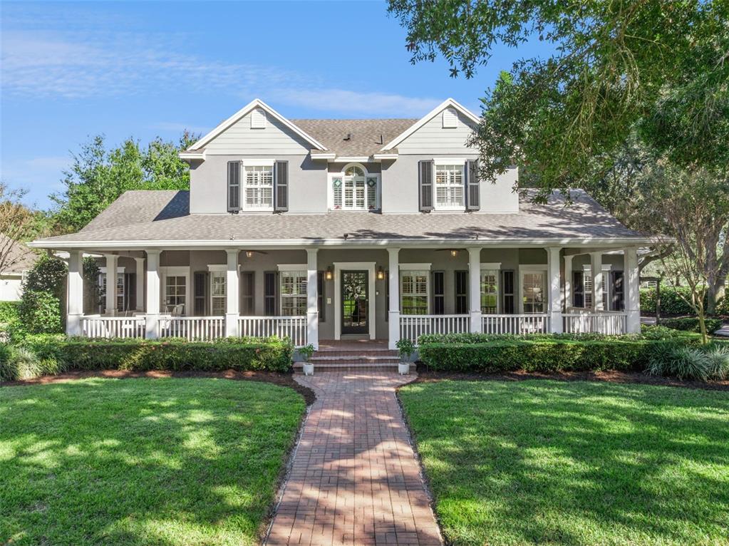 a front view of a house with a yard and potted plants