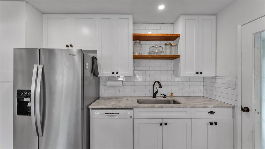 835 Chatfield Street Lakeland, FL 33803 - Photo 18 of 54 a kitchen with stainless steel appliances granite countertop a refrigerator and a sink
