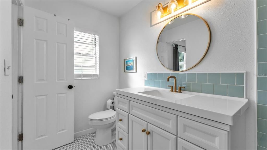 835 Chatfield Street Lakeland, FL 33803 - Photo 35 of 54 a bathroom with a toilet a sink a mirror and a window