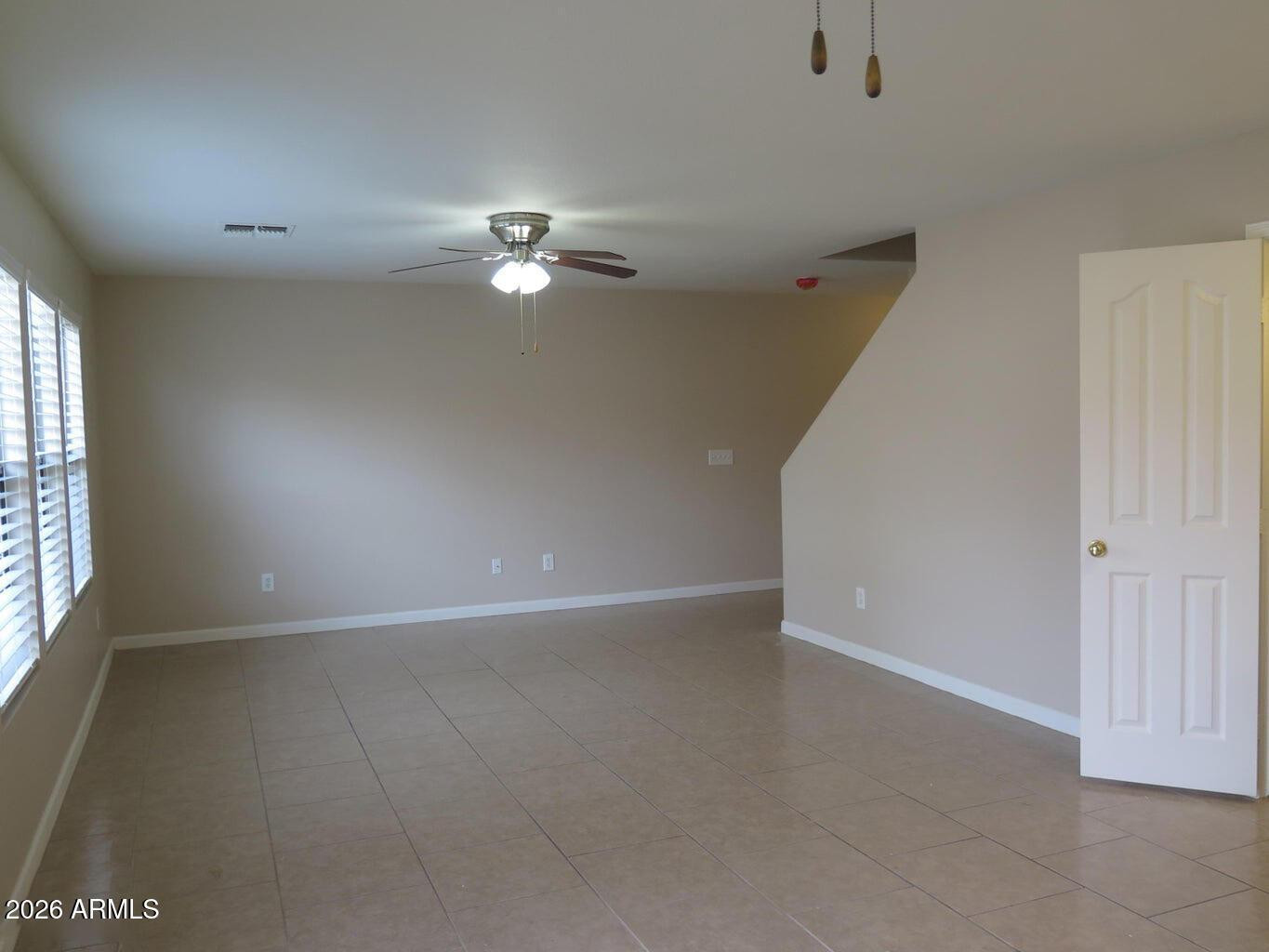3331 South Chaparral Road Apache Junction, AZ 85119 - Photo 12 of 24 an empty room with chandelier fan and windows