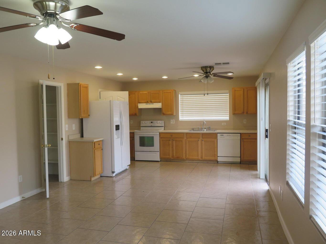 3331 South Chaparral Road Apache Junction, AZ 85119 - Photo 3 of 24 a view of a kitchen with a sink stainless steel appliances cabinets and a large window