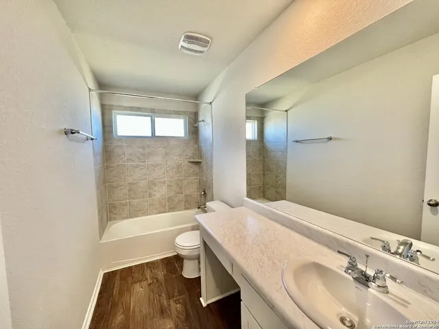 a bathroom with a granite countertop sink a toilet and shower