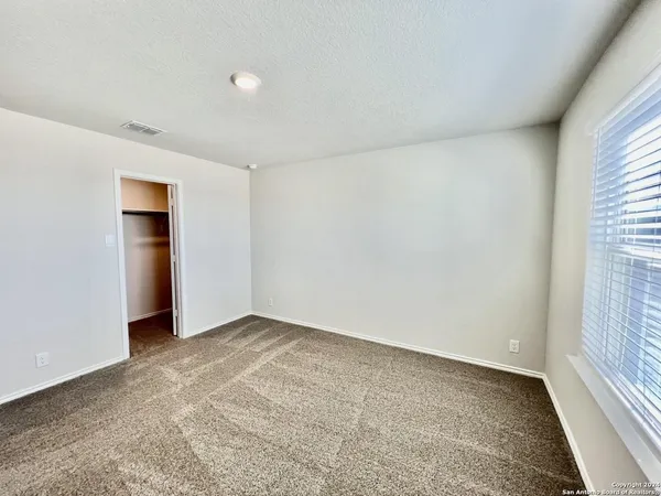 an empty room with an entryway and window