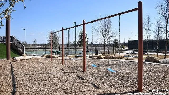 a tennis court that has a table and chairs in it
