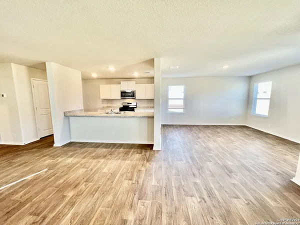 a view of a kitchen with wooden floor and electronic appliances