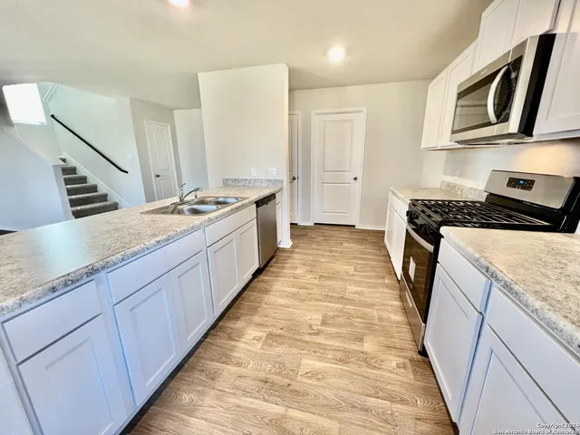a kitchen with granite countertop a stove and cabinets