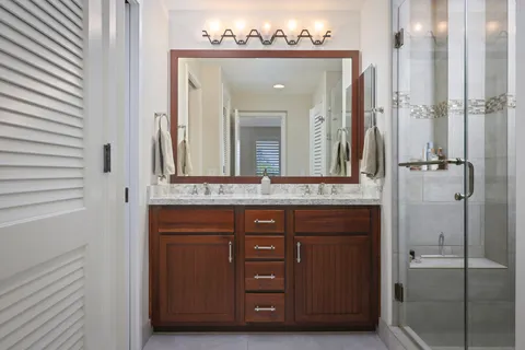 a bathroom with a granite countertop shower mirror and a sink