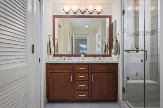 a bathroom with a granite countertop shower mirror and a sink