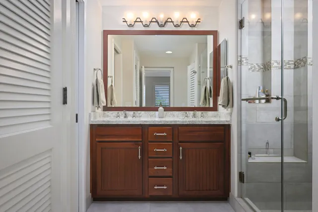 a bathroom with a granite countertop shower mirror and a sink