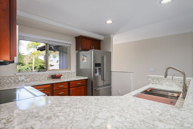 a kitchen with stainless steel appliances a sink and a refrigerator