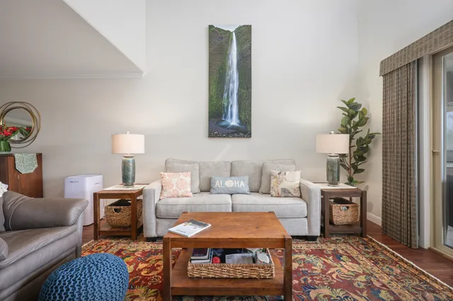a living room with furniture a rug and wall painting