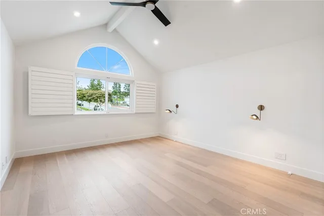 a view of an empty room and chandelier fan