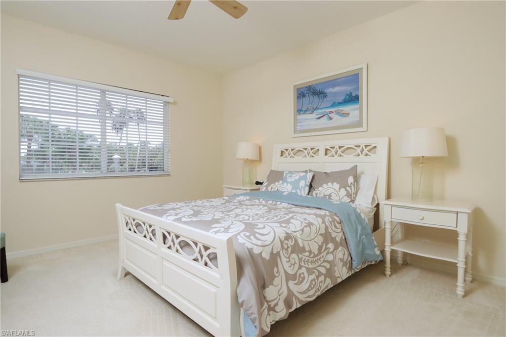 5901 Ashford Lane Naples, FL 34110 - Photo 17 of 30 a bedroom with a bed next to a window and a chair