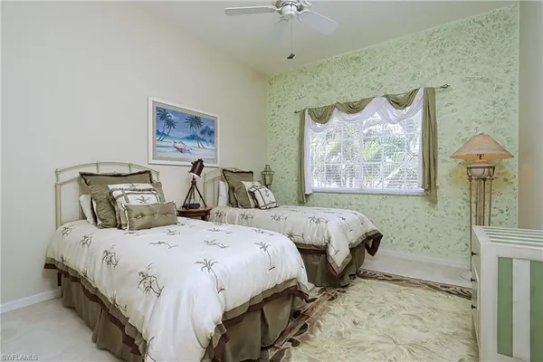 a bedroom with two beds and a painting on the wall