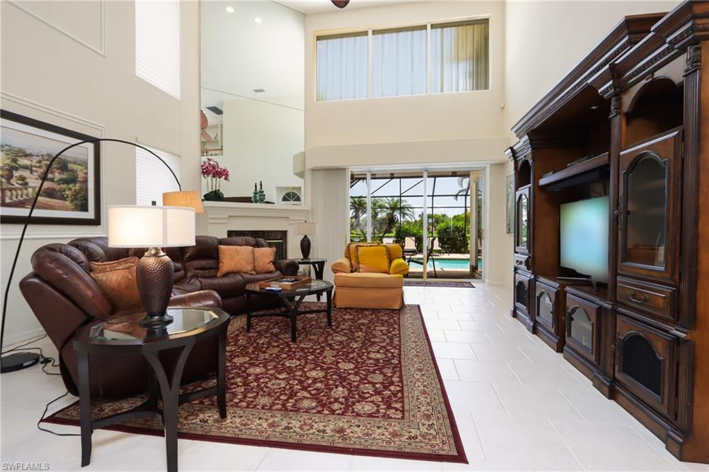 5901 Ashford Lane Naples, FL 34110 - Photo 2 of 30 a living room with furniture a flat screen tv and a fireplace