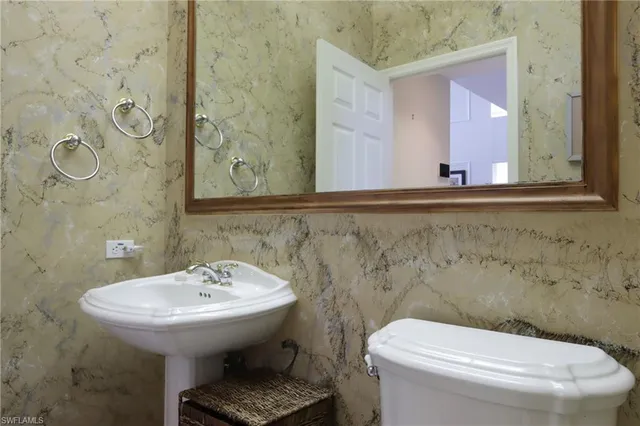 a bathroom with a toilet sink and mirror