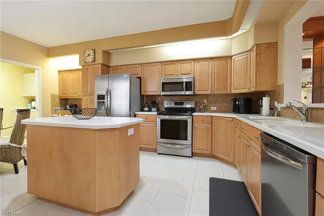 a kitchen with stainless steel appliances a sink a stove a microwave a sink a refrigerator and cabinets