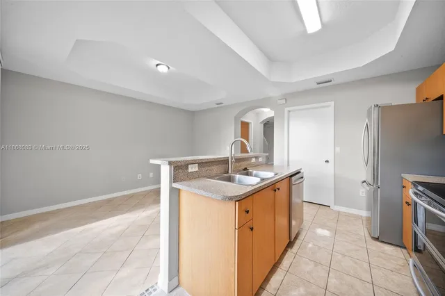 a kitchen with stainless steel appliances granite countertop a sink and a stove