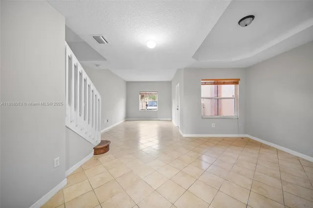 a view of a hallway with wooden floor and a bathroom