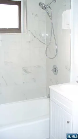 a bathroom with a bath tub a shower and a sink