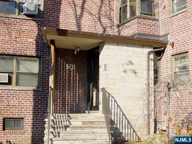 a view of a brick house with many windows
