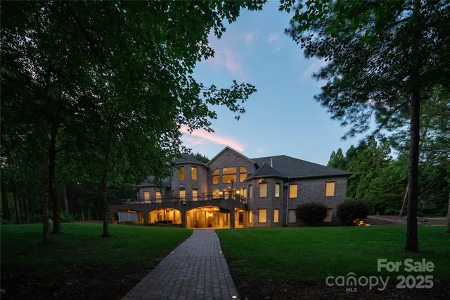 a view of a big yard with plants and large trees