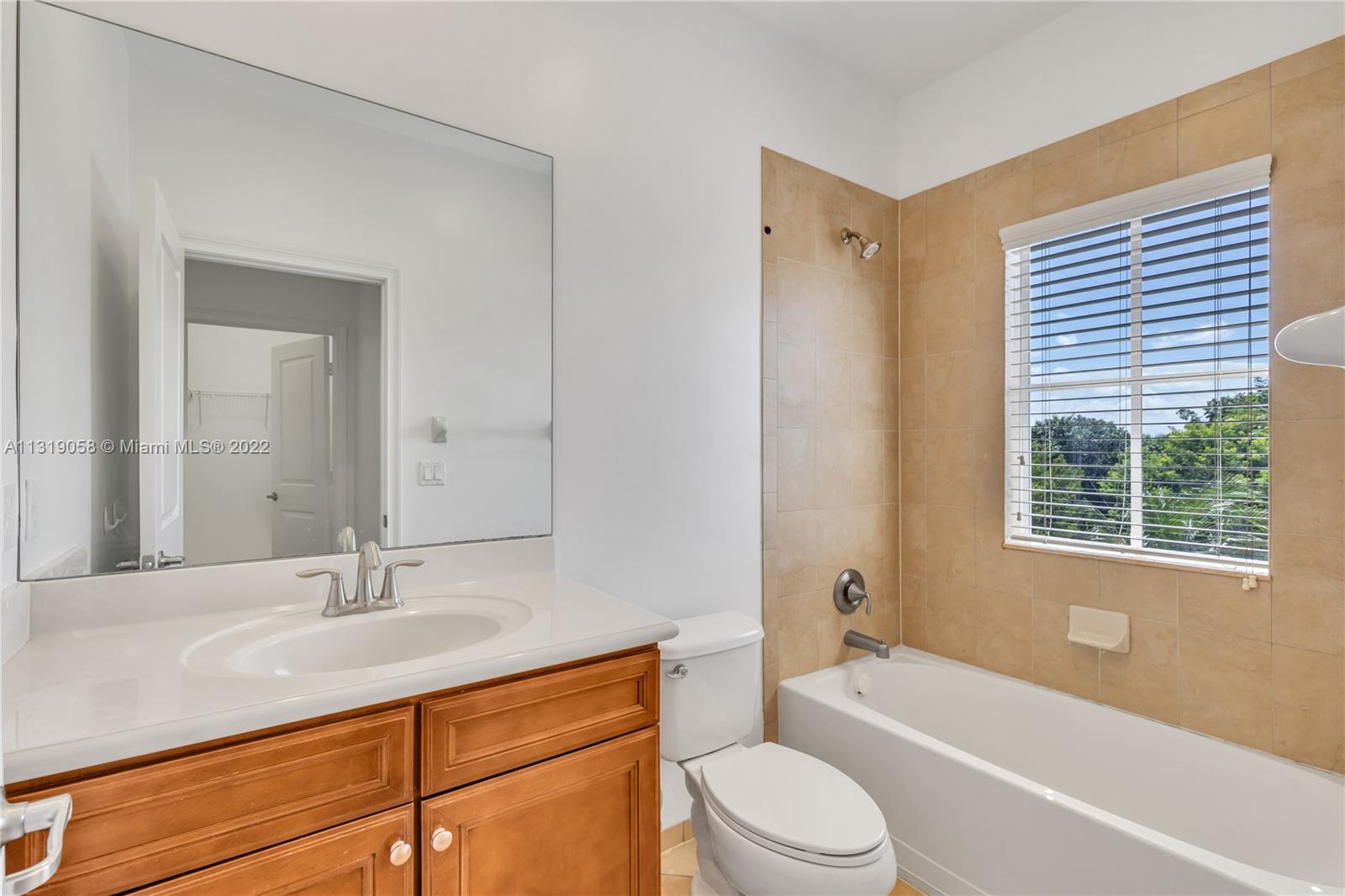 674 Northwest Library Commons Way, Unit 674 Boca Raton, FL 33432 - Photo 18 of 20 a bathroom with a granite countertop sink toilet tub and shower