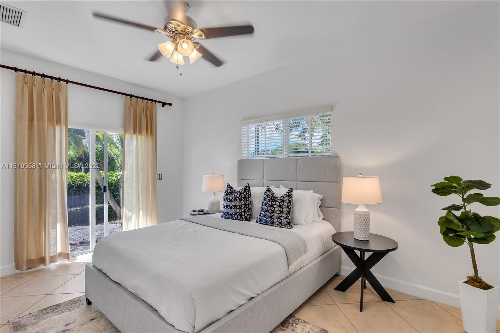 674 Northwest Library Commons Way, Unit 674 Boca Raton, FL 33432 - Photo 4 of 20 a bedroom with a bed and a chandelier