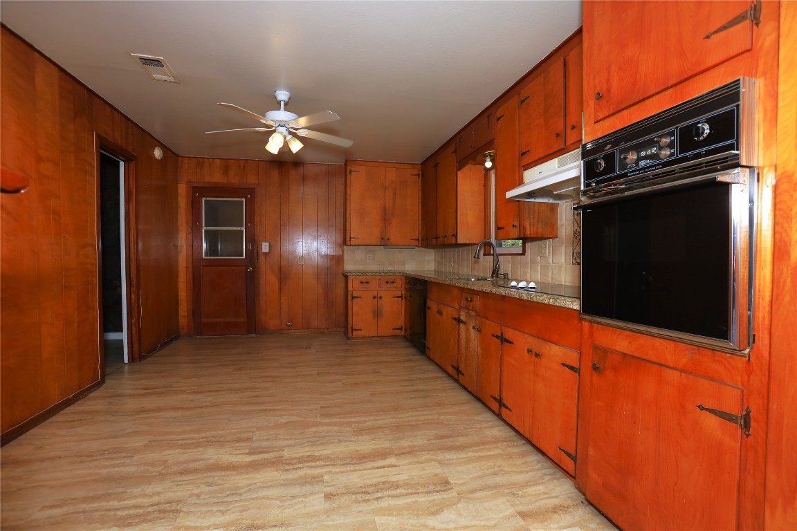 700 Wesley Drive Clute, TX 77531 - Photo 9 of 27 a kitchen with stainless steel appliances granite countertop a refrigerator a sink dishwasher a stove and a refrigerator with wooden cabinets