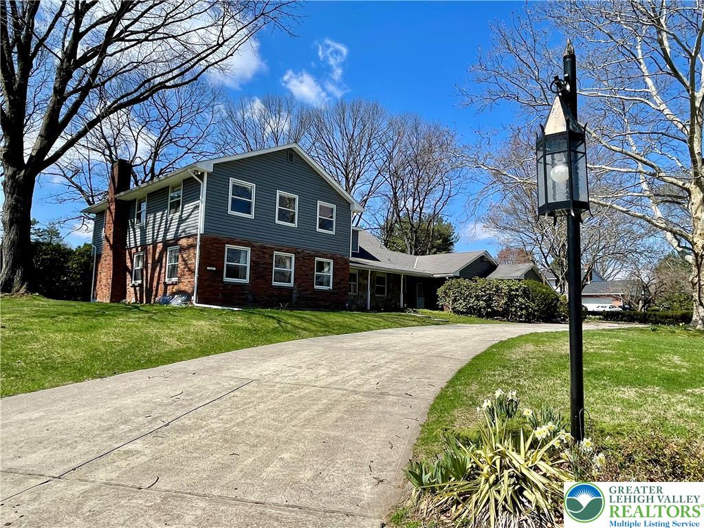 1331 Armstrong Road Bethlehem, PA 18017 - Photo 4 of 47 a view of a brick house next to a yard with big trees