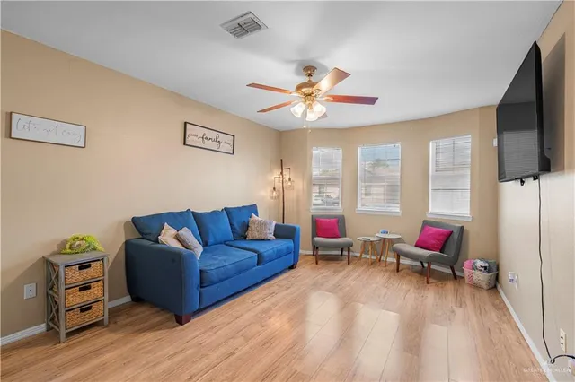 a living room with furniture flat screen tv and a large window