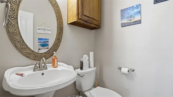 a bathroom with a toilet a sink and a mirror