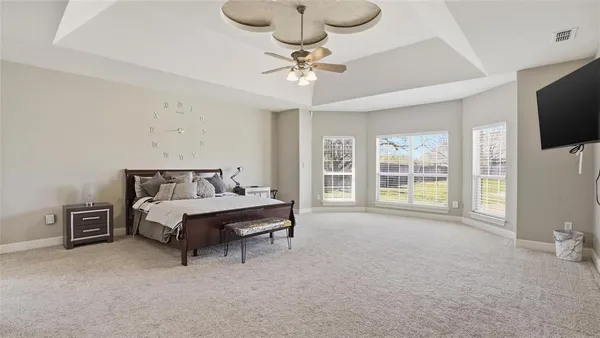 a spacious bedroom with a bed and a flat screen tv