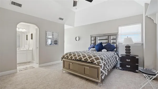 a bed sitting in a bedroom next to a window and a dresser